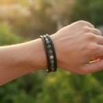Homme portant un bracelet en cuir tressé noir avec perles d'agate mousse verte et fermoir magnétique