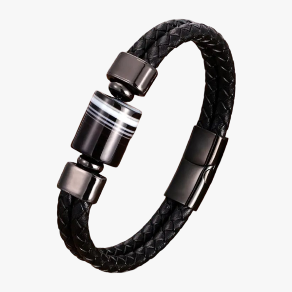 Gros plan d'un bracelet homme en cuir tressé noir avec perles de pierre de lave sur fond pierre claire