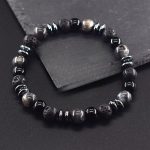 Bracelet Homme Pierre de Lave et Œil de Faucon poser sur un rocher