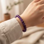 Poignet portant un bracelet élastique en perles d'améthyste violette translucide