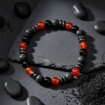 Bracelet homme en agate rouge, onyx, pierre de lave et hématite présenté sur ardoise