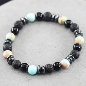 Gros plan d'un bracelet homme en amazonite turquoise, onyx noir, pierre de lave et hématite sur fond pierre claire