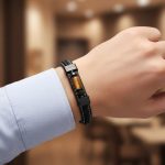 Poignet d'un homme portant un bracelet en cuir noir tressé et plat avec tube central en œil de tigre et fermoir magnétique