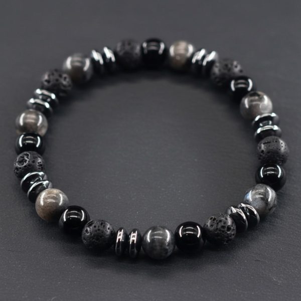 Gros plan d'un bracelet homme en larvikite grise, onyx noir, pierre de lave et hématite sur fond ardoise