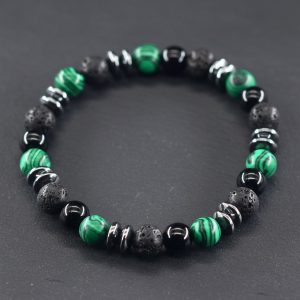 Gros plan d'un bracelet homme en malachite verte, onyx noir, pierre de lave et hématite sur fond ardoise