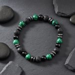 Bracelet homme en malachite, onyx, pierre de lave et hématite présenté sur ardoise