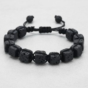 Gros plan d'un bracelet homme en cubes de pierre de lave tissé macramé sur cordon ajustable