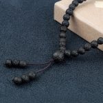 Gros plan sur la perle guru et le pompon en pierre de lave d'un mala tibétain 108 perles