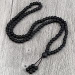 Mala tibétain 108 perles en pierre de lave présenté en spirale sur ardoise avec éléments zen