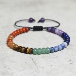 Gros plan d'un bracelet 7 chakras en rondelles de pierres naturelles multicolores sur bois