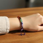 Poignet portant un bracelet 7 chakras en pierres naturelles multicolores sur cordon ajustable