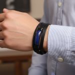 Poignet d'un homme portant un bracelet en cuir noir multi-rangs avec barre en lapis-lazuli et fermoir magnétique