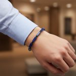 Poignet d'un homme portant un bracelet ajustable en bâtonnets de lapis-lazuli et hématite