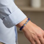 Poignet d'un homme portant un bracelet en lapis-lazuli poli et brut avec rondelles dorées
