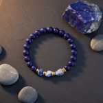 Bracelet homme en lapis-lazuli poli et brut avec rondelles dorées présenté sur ardoise