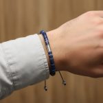 Poignet d'un homme portant un bracelet ajustable en rondelles de lapis-lazuli et acier