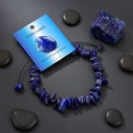 Bracelet en chips de lapis-lazuli présenté sur ardoise avec pierre brute
