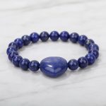 Gros plan d'un bracelet en lapis-lazuli avec cœur central sur fond clair