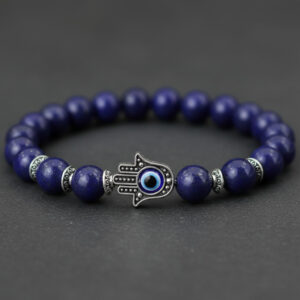 Gros plan d'un bracelet en lapis-lazuli avec main de Fatma en argent et œil bleu protecteur sur fond sombre