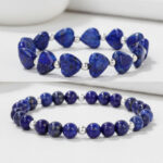 Gros plan d'un ensemble de deux bracelets en lapis-lazuli, cœurs et perles rondes sur fond clair