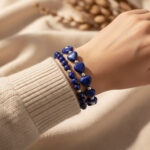 Poignet portant un ensemble de deux bracelets en lapis-lazuli, cœurs et perles rondes avec perles argentées