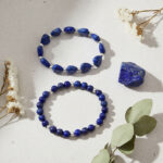 Ensemble de deux bracelets en lapis-lazuli, cœurs et perles présenté sur pierre claire avec cristal