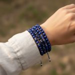 Poignet portant un ensemble de bracelets en lapis-lazuli de styles variés avec perles acier