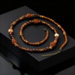 ollier perles de bois homme long perles mixtes sculptées symbole om anneaux laiton doré fond noir