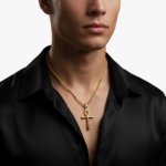 Collier croix homme ankh égyptienne doré acier inoxydable porté sur chemise noire fond blanc
