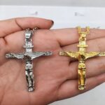 Collier croix de Jésus homme acier inoxydable argent et doré deux variantes dans la main