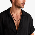 Collier cordon cuir marron homme tressé porté chemise noire ouverte vue de face