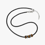 Collier cuir noir homme perles œil de tigre marron rondelles acier argenté cordon tressé fermoir mousqueton vue à plat fond