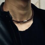 Collier cuir tresse homme ras du cou marron fermoir magnetique argente porte sur veste noire