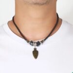 Collier homme cordon cuir marron tressé pendentif pointe de flèche bronze tribal porté sur t-shirt blanc