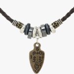 Zoom pendentif pointe de flèche bronze tribal gravé sur cordon cuir marron tressé avec anneaux hématite noire et perles acier argenté