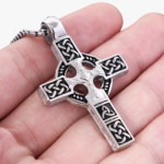 Pendentif croix celtique entrelacs argent oxydé acier inoxydable tenu dans la main