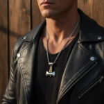 Collier homme pendentif hache viking acier inoxydable bicolore argent et or porte veste cuir noire fond bois
