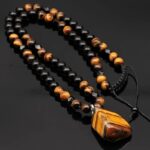 Collier oeil de tigre homme marron perles obsidienne noire pendentif pierre brute naturelle sur fond noir