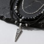 Collier pendentif homme triangle argenté perles onyx noires multi-rangs cordon noir fond ardoise gros plan