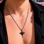 Collier pendentif homme raie manta acier inoxydable argenté porté sur chemise noire ouverte vue de face