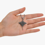 Pendentif raie manta acier inoxydable argenté vieilli tenu dans la main pour montrer la taille