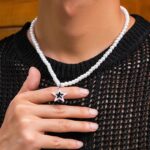 Collier homme perle blanche nacrée pendentif étoile argentée zircon noir porté sur pull noir