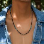 ollier perle homme rocaille noir turquoise blanc argente porte sur veste en jean fond nature